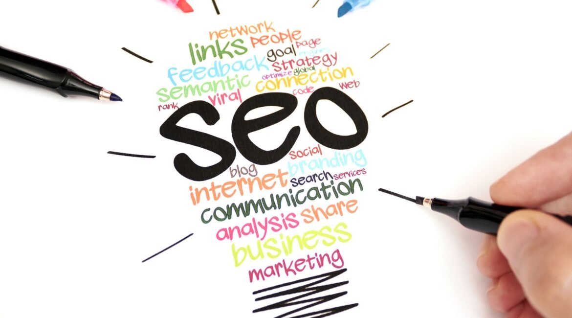 Bombilla formada por palabras relacionadas con SEO (estrategia, enlaces, comunicación) con rotuladores de colores alrededor.