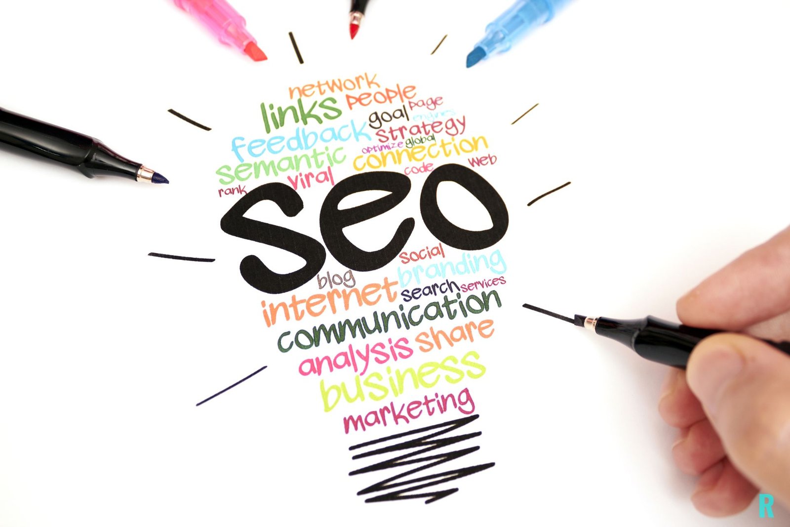 Bombilla formada por palabras relacionadas con SEO (estrategia, enlaces, comunicación) con rotuladores de colores alrededor.